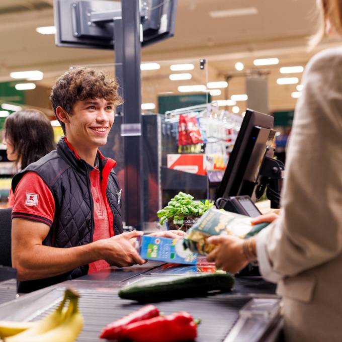 An der Kasse in einer Kaufland-Filiale: Junger Mitarbeiter kassiert den Einkauf einer Kundin.