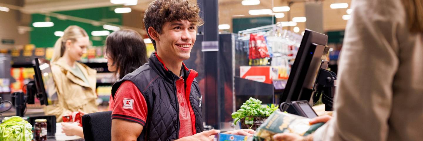 An der Kasse in einer Kaufland-Filiale: Junger Mitarbeiter kassiert den Einkauf einer Kundin.