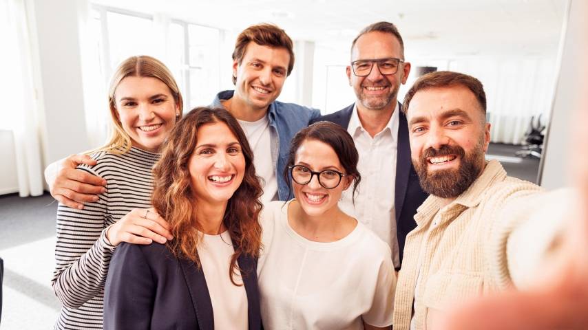 Sechs Kaufland-Mitarbeiter posieren zum Gruppenbild im Büro.