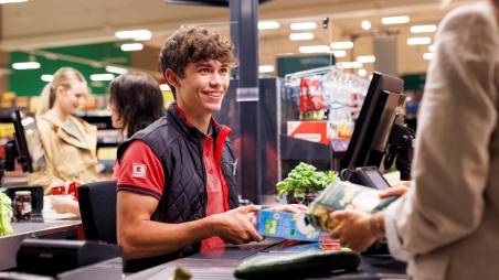 An der Kasse in einer Kaufland-Filiale: Junger Mitarbeiter kassiert den Einkauf einer Kundin.